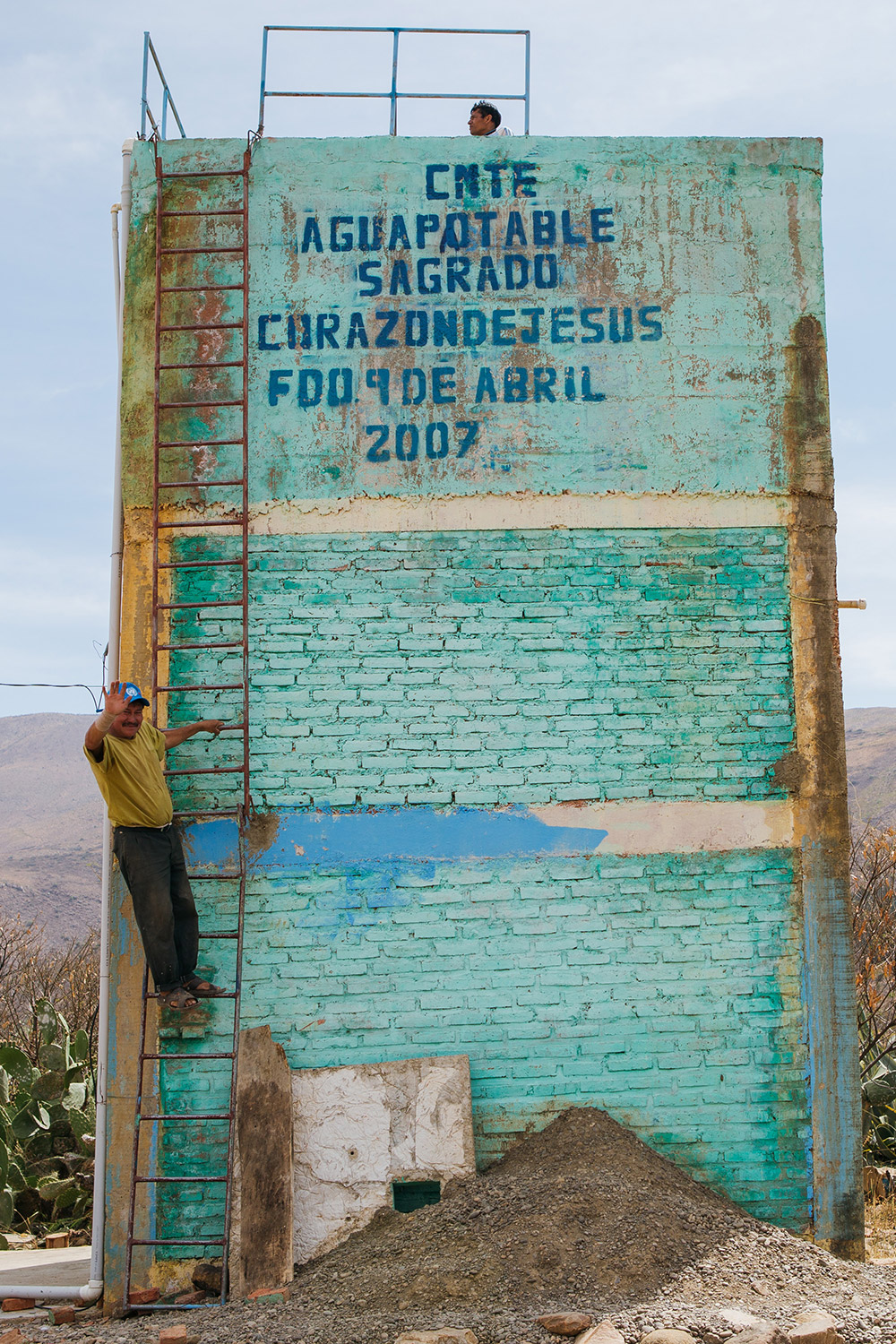 man climbing a ladder on a brick building | Clean Water in Bolivia | Where We Work | Water For People