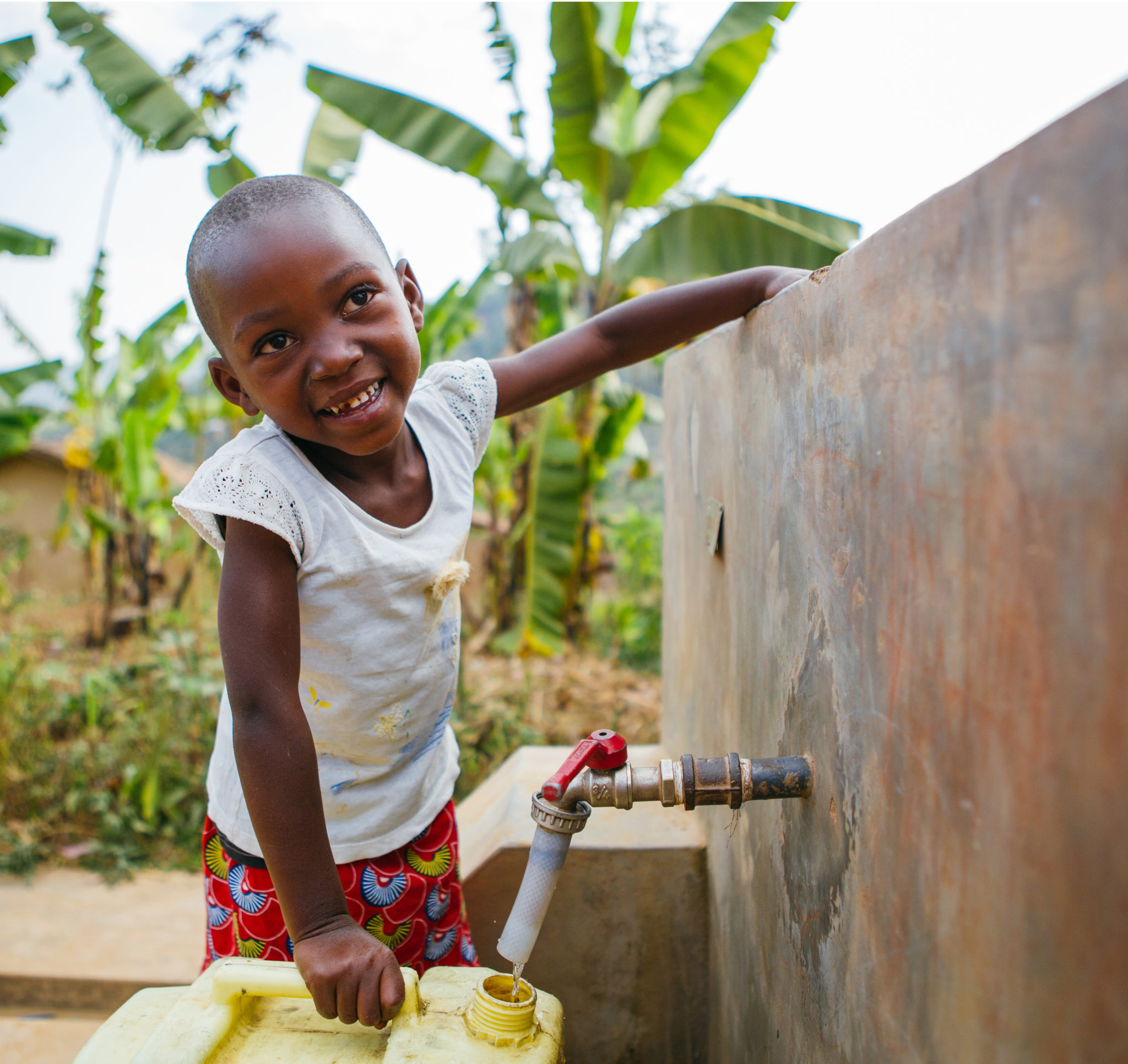 happy child filling up water jug | The Progress, Milestones & Stats | Water For People