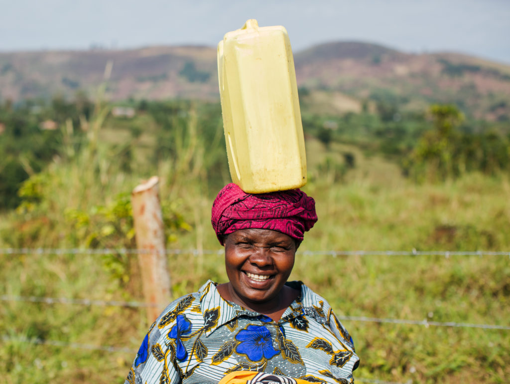 lady with water jug on head | The Strategy to Achieve SDG 6 | Water For People