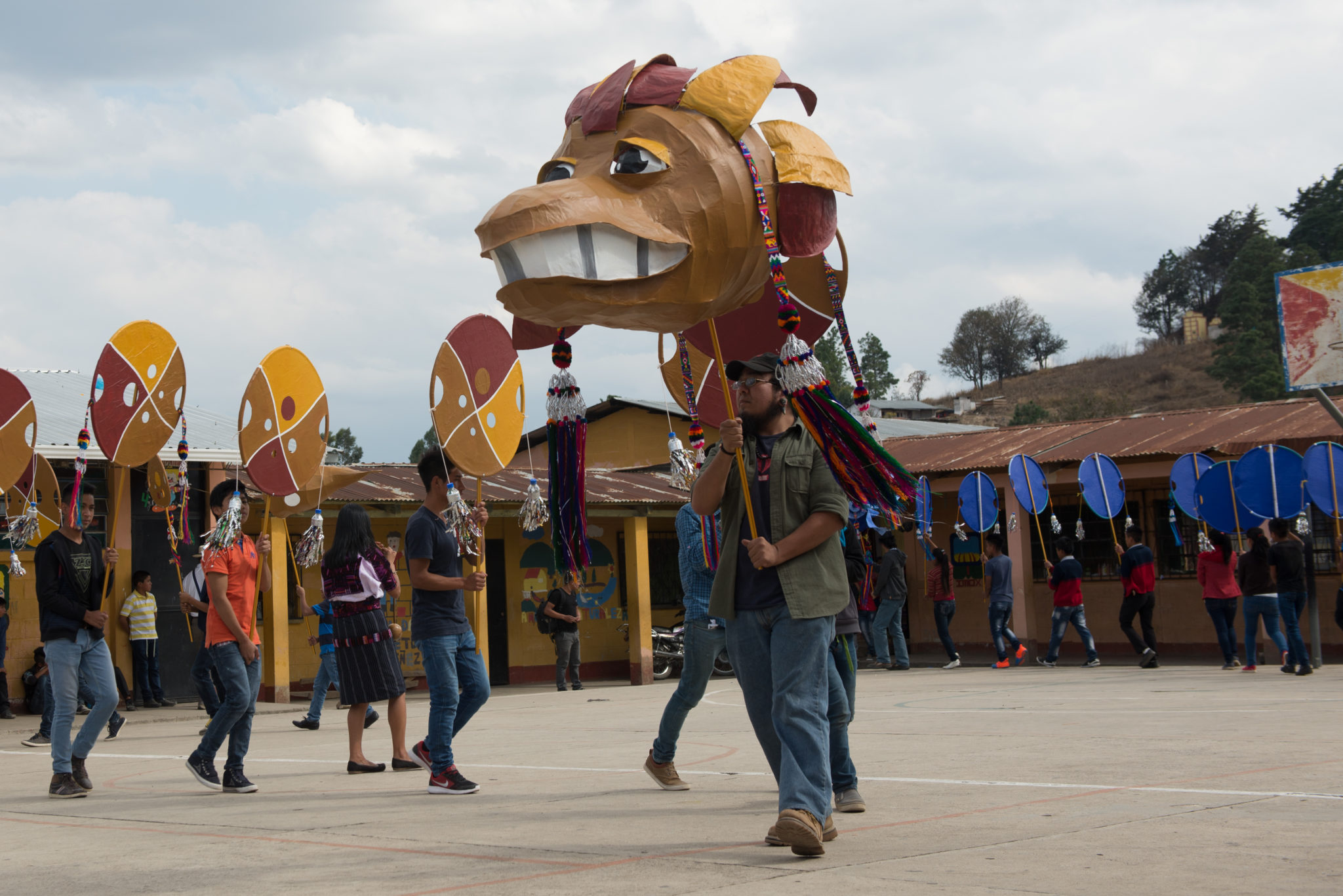 Guatemala-SantaCruzdelQuiche-201703-92 Photograph of several people in a town square holding up large puppets during a street performance