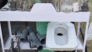 Photograph of toilet parts and pipes on a shelf