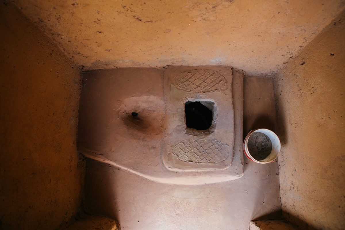 Photo of a pit latrine with a stone slab platform.