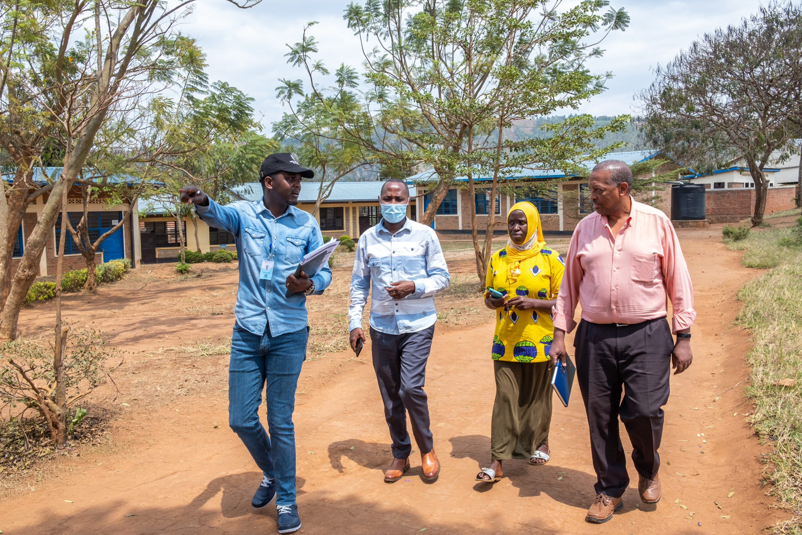 Co-CEO Samson Hailu Bekele (far right) walks with community members in Rwanda. 