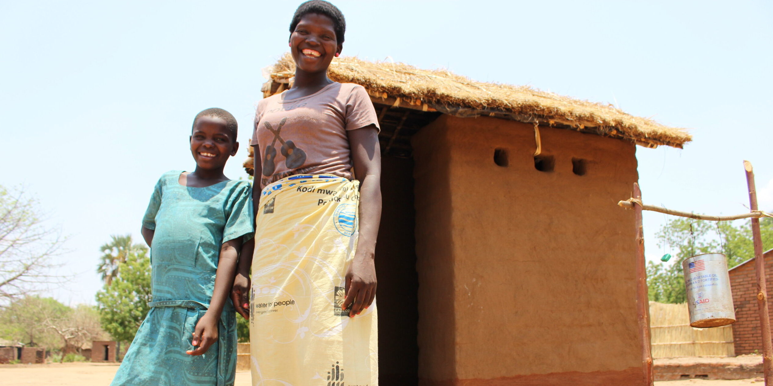 A woman standing with her daugther at a newly constructed latrine