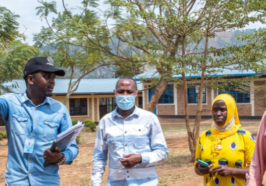 Co-CEO Samson Hailu Bekele (far right) walks with community members in Rwanda. 